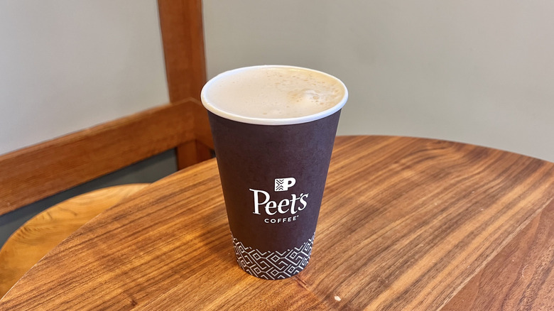 Pistachio rose latte from Peet's on a wooden table