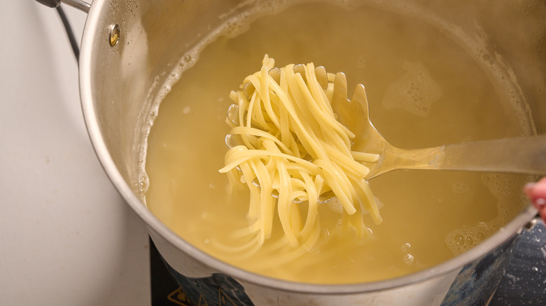 lifting pasta out of boiling water