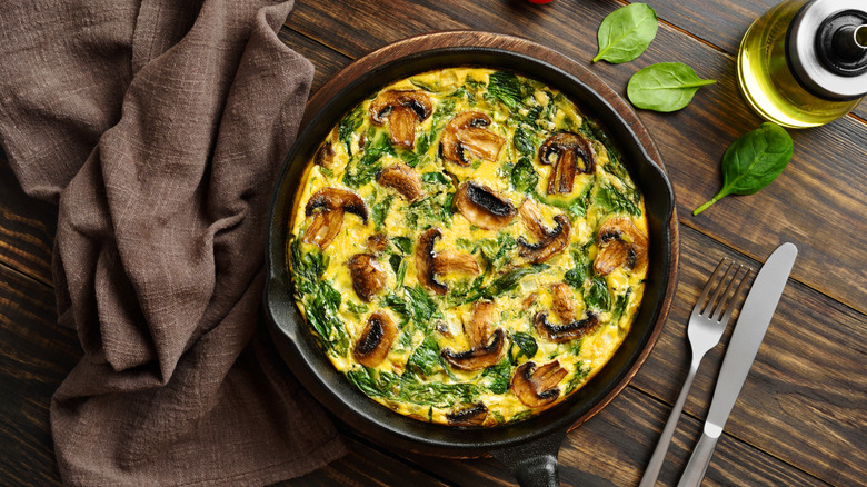 omelet in cast iron pan on wood board