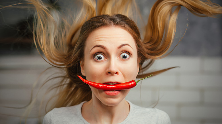 woman holding spicy chili pepper