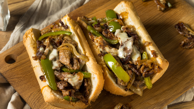 Philly cheesesteak sandwiches on chopping board