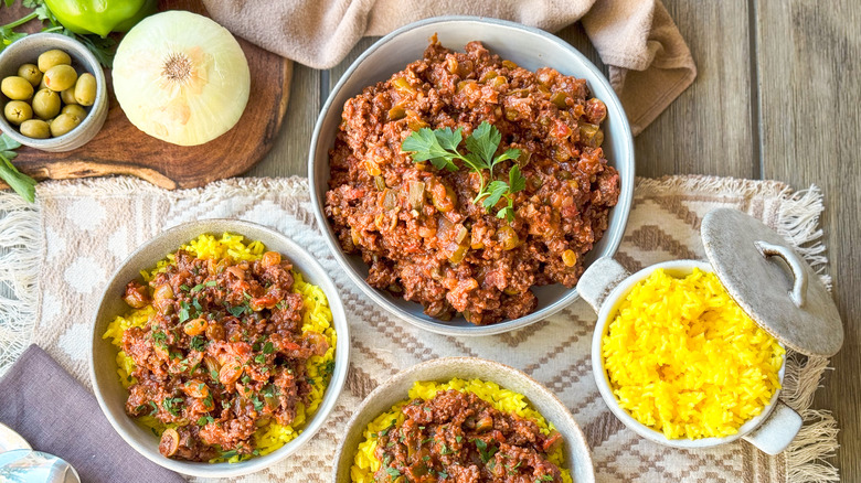 Picadillo with saffron rice in serving dishes on table