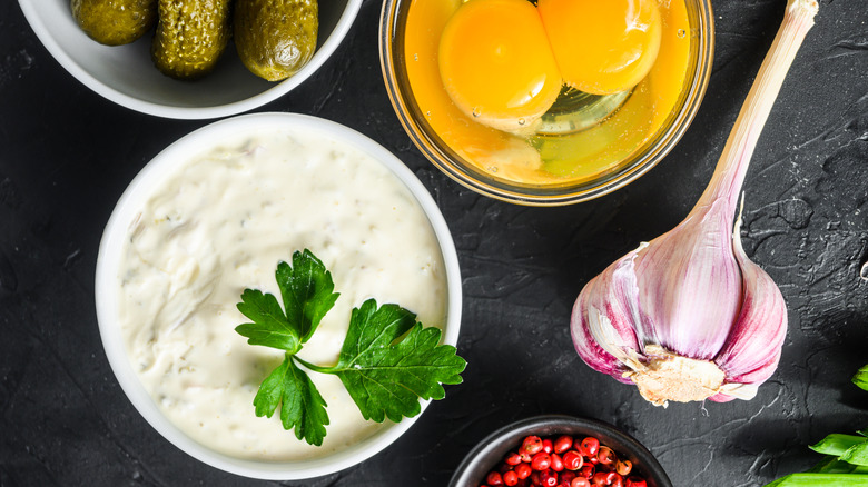 Ranch dressing next to pickles and other ingredients