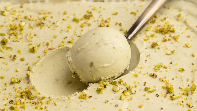 A closeup of a spoonful of 3-ingredient pistachio ice cream sitting on top of the ice cream
