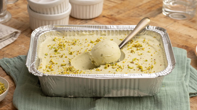 3-ingredient pistachio ice cream in foil container with one scoop on a spoon