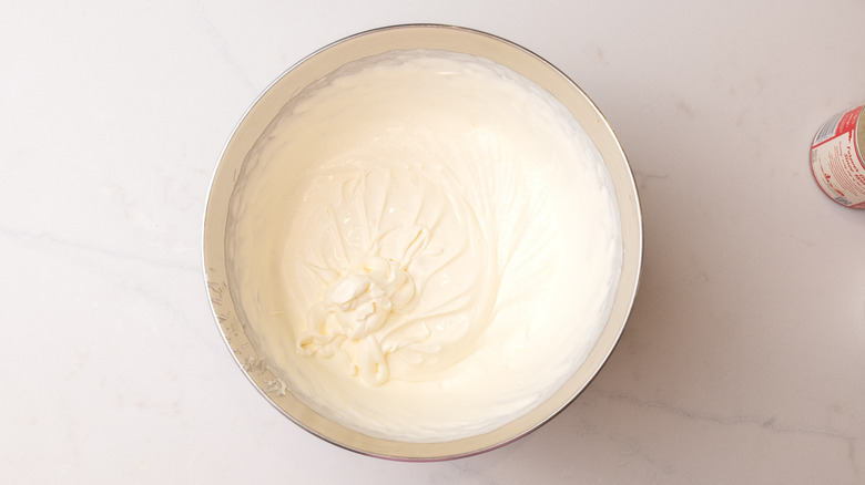Aerial view of softly whipped cream with soft peaks in mixing bowl