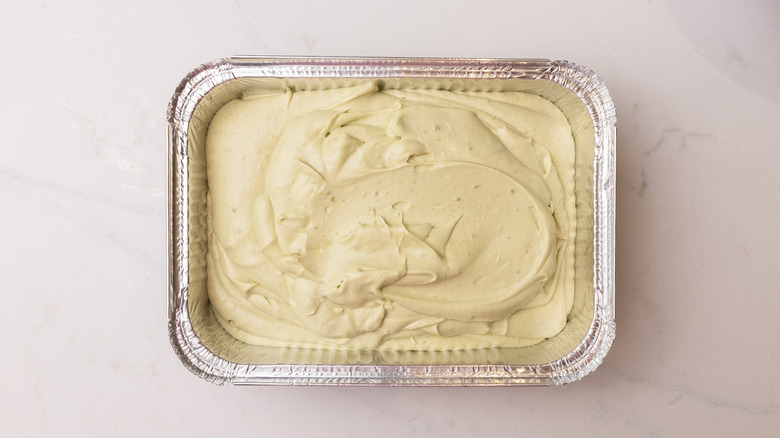 Aerial view of pistachio ice cream mixture in foil container