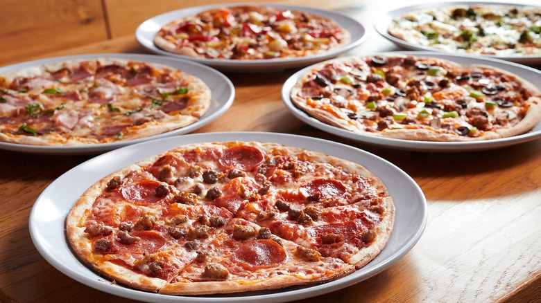 Five pizzas from MOD Pizza on a restaurant table