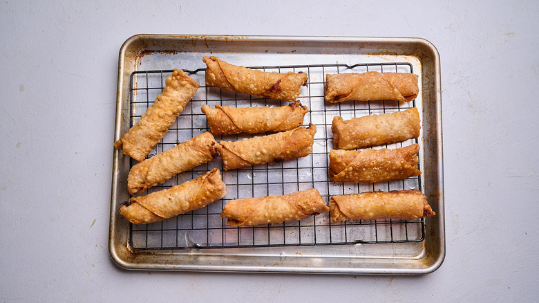 draining egg rolls on a wire rack