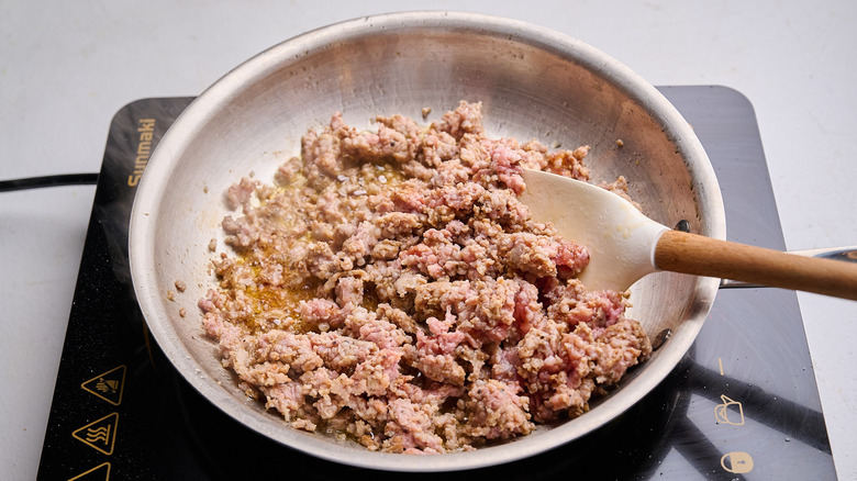 browning and crumbling sausage in a skillet