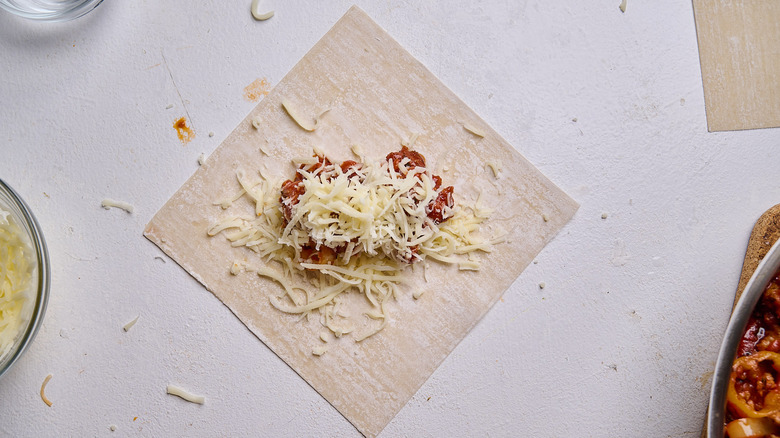pizza sauce and cheese on egg roll wrapper