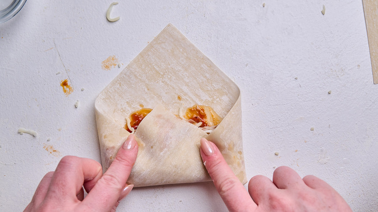 folding sides of wrapper over the bottom