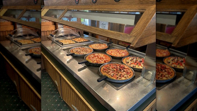 Mirrored image of pizzas on the buffet at pizza hut