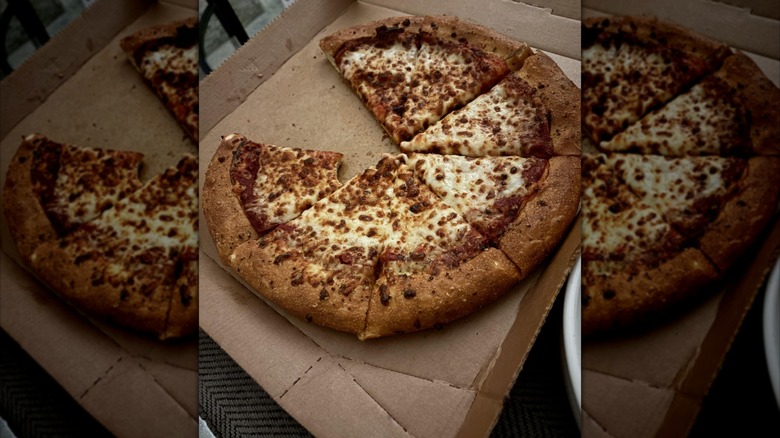 half eaten pizza in box, mirrored image