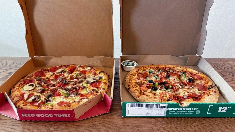 side view of two supreme pizzas in boxes