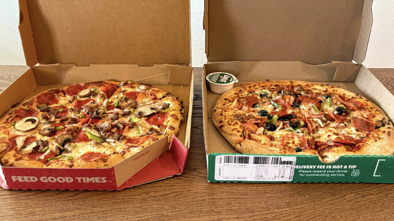 Two pizzas in their cardboard boxes