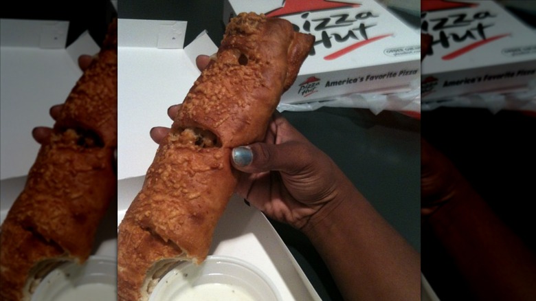 Hand holding a P'Zolo from Pizza Hut