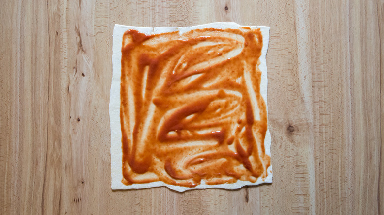 tomato puree on pastry sheet