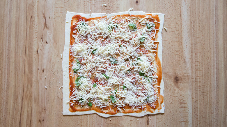 unbaked pizza on wooden table