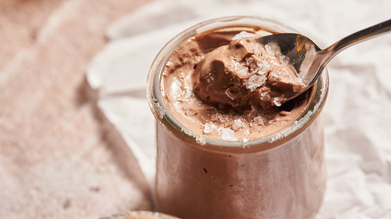 spoon lifting chocolate mousse out of jar