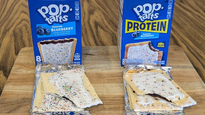 Two boxes of blueberry Pop-Tarts and two unwrapped Pop-Tarts on a wooden table