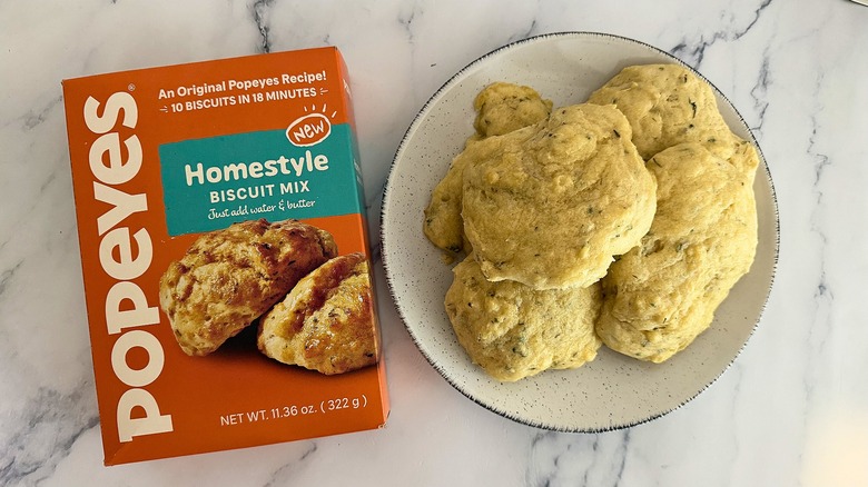 Popeyes Homestyle Biscuit Mix box next to biscuits on plate on marble surface