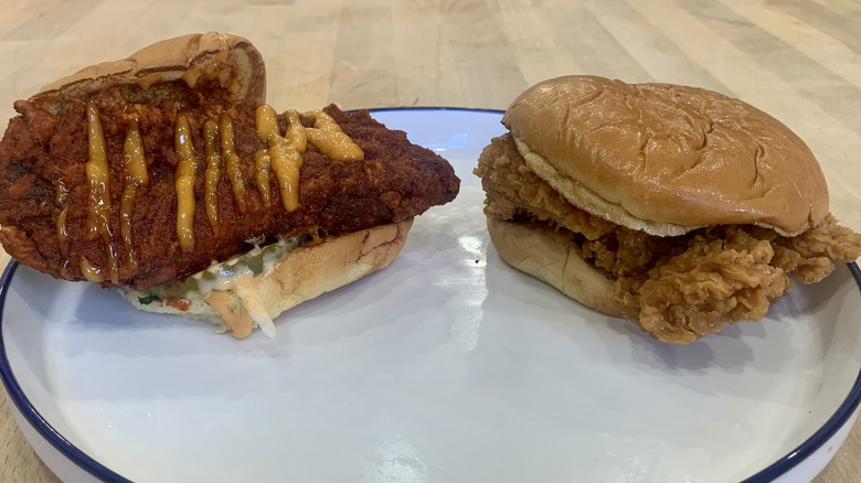 Popeyes sandwich and Dave's slider on white plate with wood background