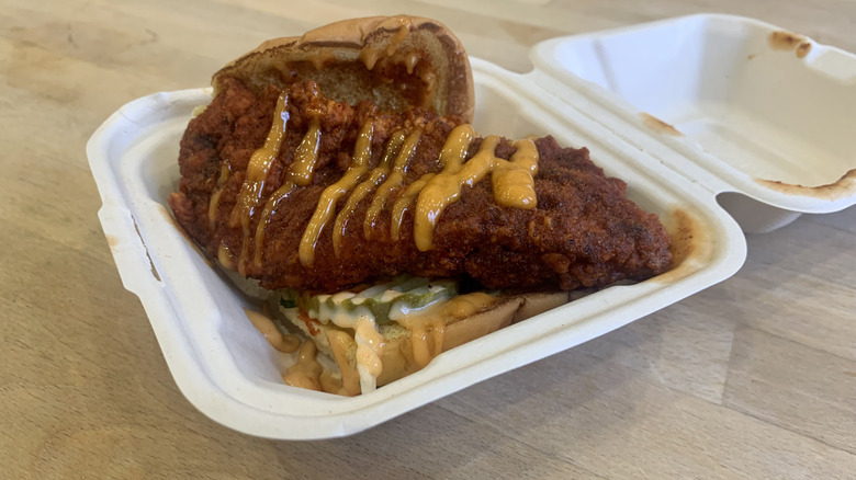 Dave's Hot Chicken slider in white container with wood background