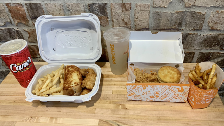 Raising Cane's and Popeyes chicken tender meals in open containers