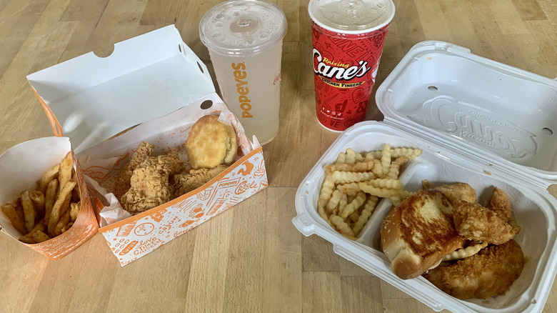 Raising Cane's and Popeyes chicken tender meals in open containers