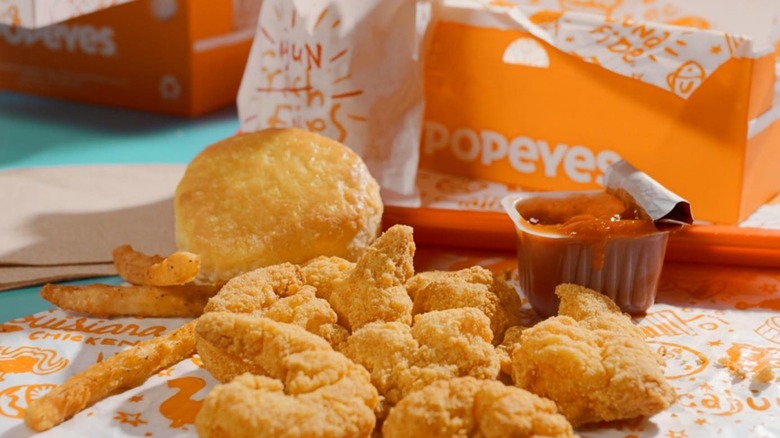 Popeyes shrimp and fries beside a biscuit and a package of red sauce