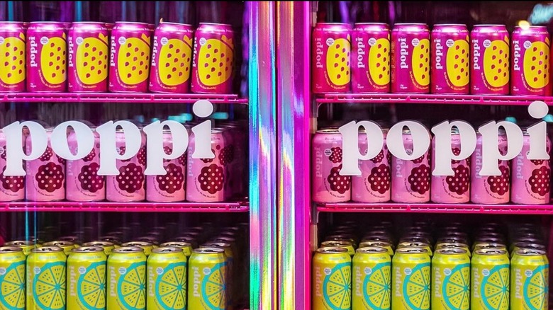Rows of Poppi cans in a glass refrigerator