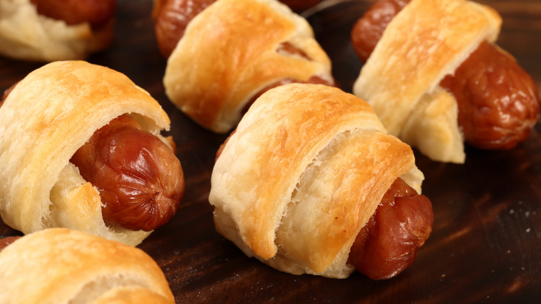 Close-up on pigs in blankets on a wooden surface