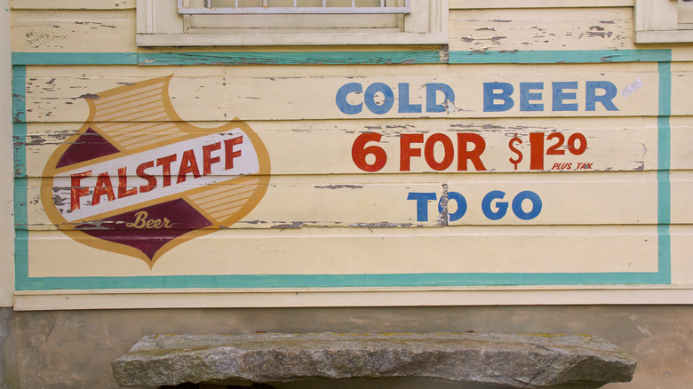 A wooden Falstaff sign reading "Cold Beer 6 for $1.20 To Go"