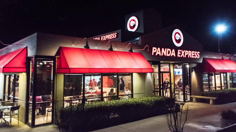 Storefront of a well-lit Panda Express, photographed at night.