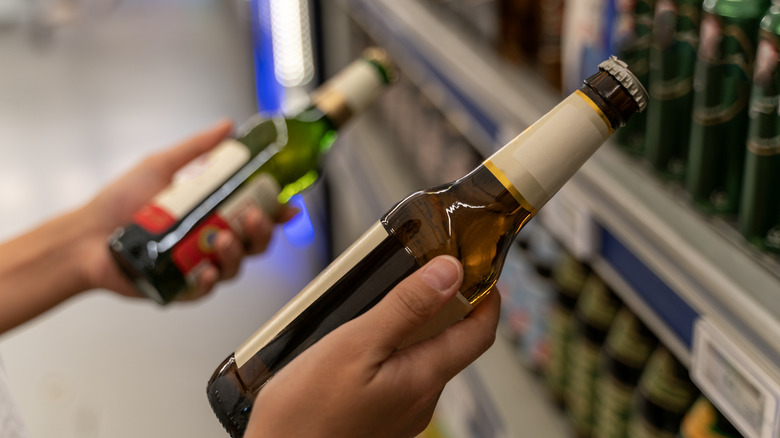person holding two bottles of beer