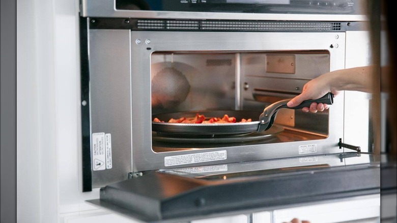 KitchenAid microwave oven with bacon cooking inside.