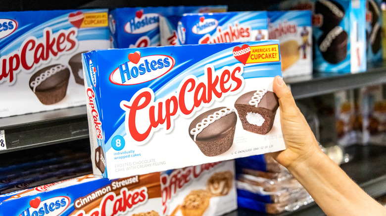 Hand holding a box of Hostess CupCakes at grocery store