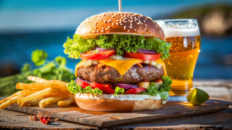 Deluxe cheeseburger with fries and a glass of beer