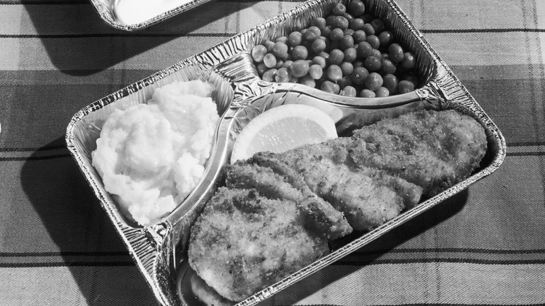 Black-and-white photo of a classic TV dinner in an aluminum tray