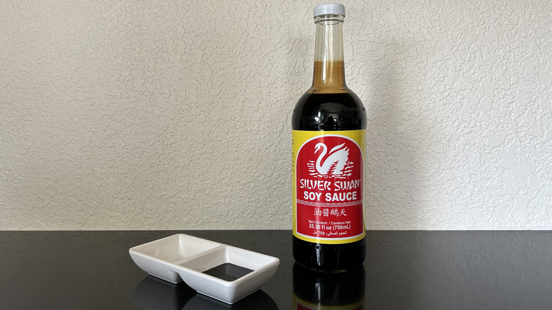 A large bottle of Silver Swan soy sauce next to dipping dish