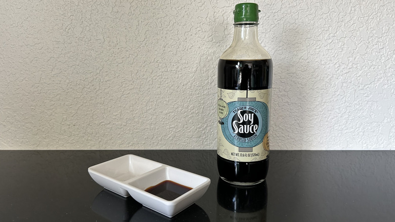 A medium-sized bottle of Trader Joe's soy sauce with dipping dish