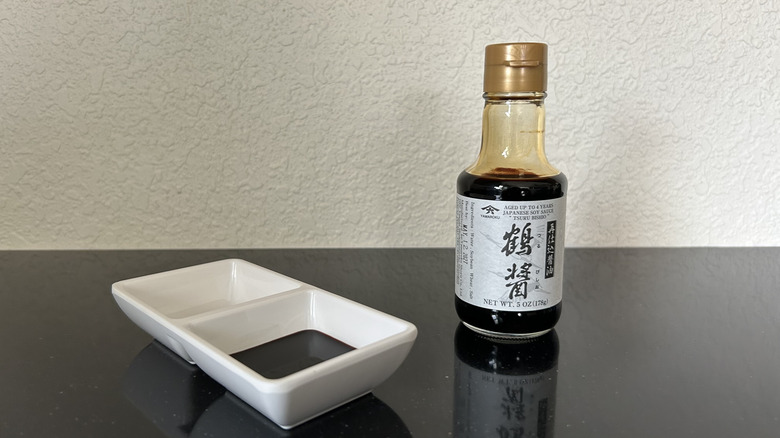 A small bottle of Yamaroku soy sauce and sauce dish
