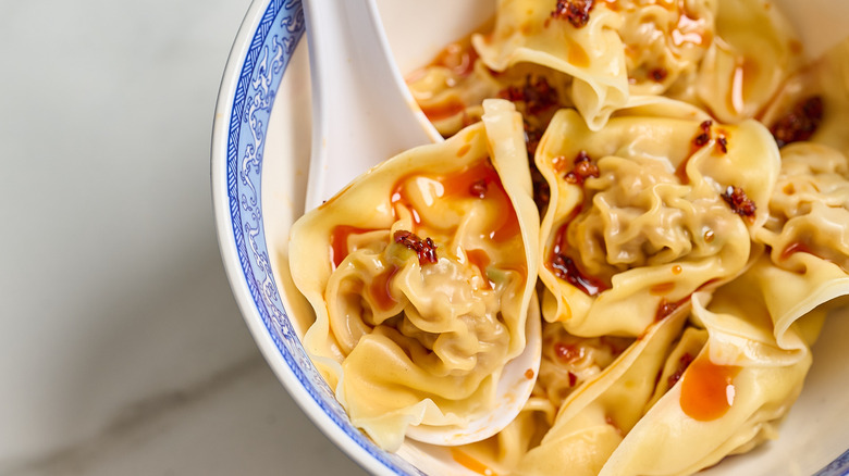 wonton on a spoon covered in chili oil