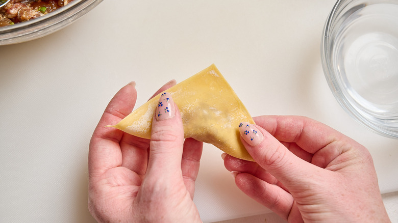 sealing sides together to form a triangle