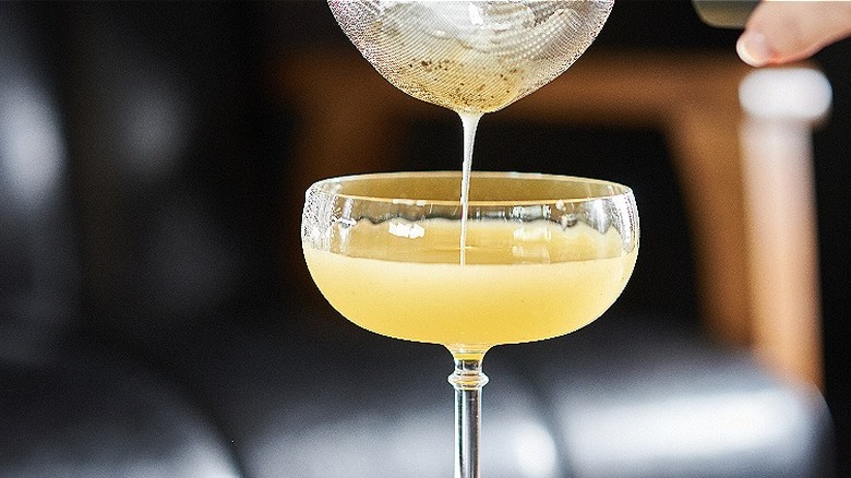 straining drink into glass