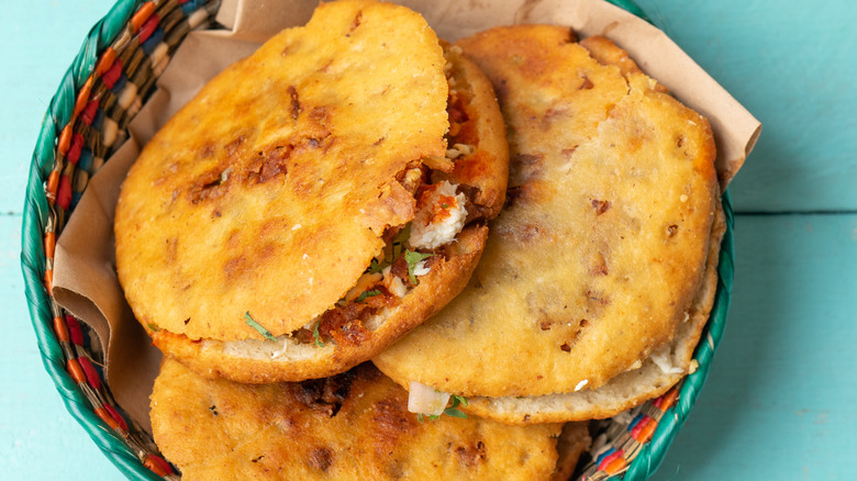 plate of three gorditas stacked on a turquoise background
