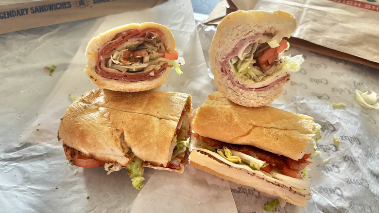 Two pieces of Potbelly and Capriotti's Italian subs displayed on sandwich wrappers