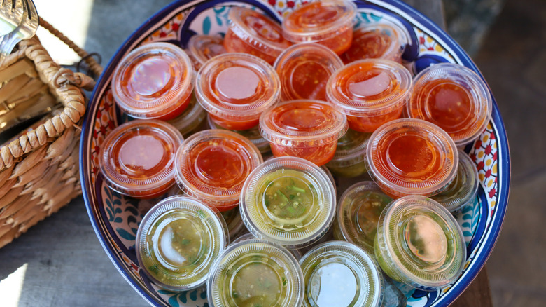 A bowl of salsa in small portioned containers