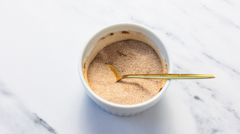 Cinnamon sugar with spoon in bowl.